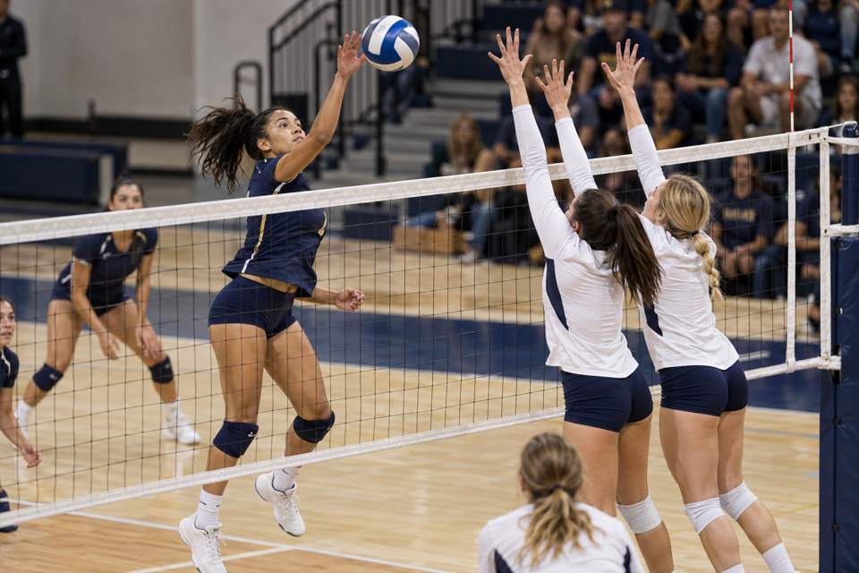 Women's volleyball player attacking at the net